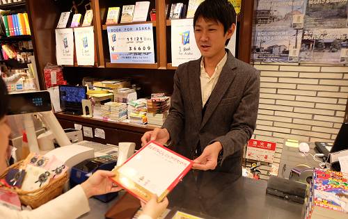 本屋で本を購入する様子