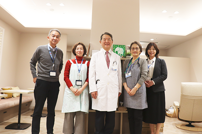 磯部院長とファミリールームを運営する皆さん。さまざまな組織や立場の人たちが連携しています。